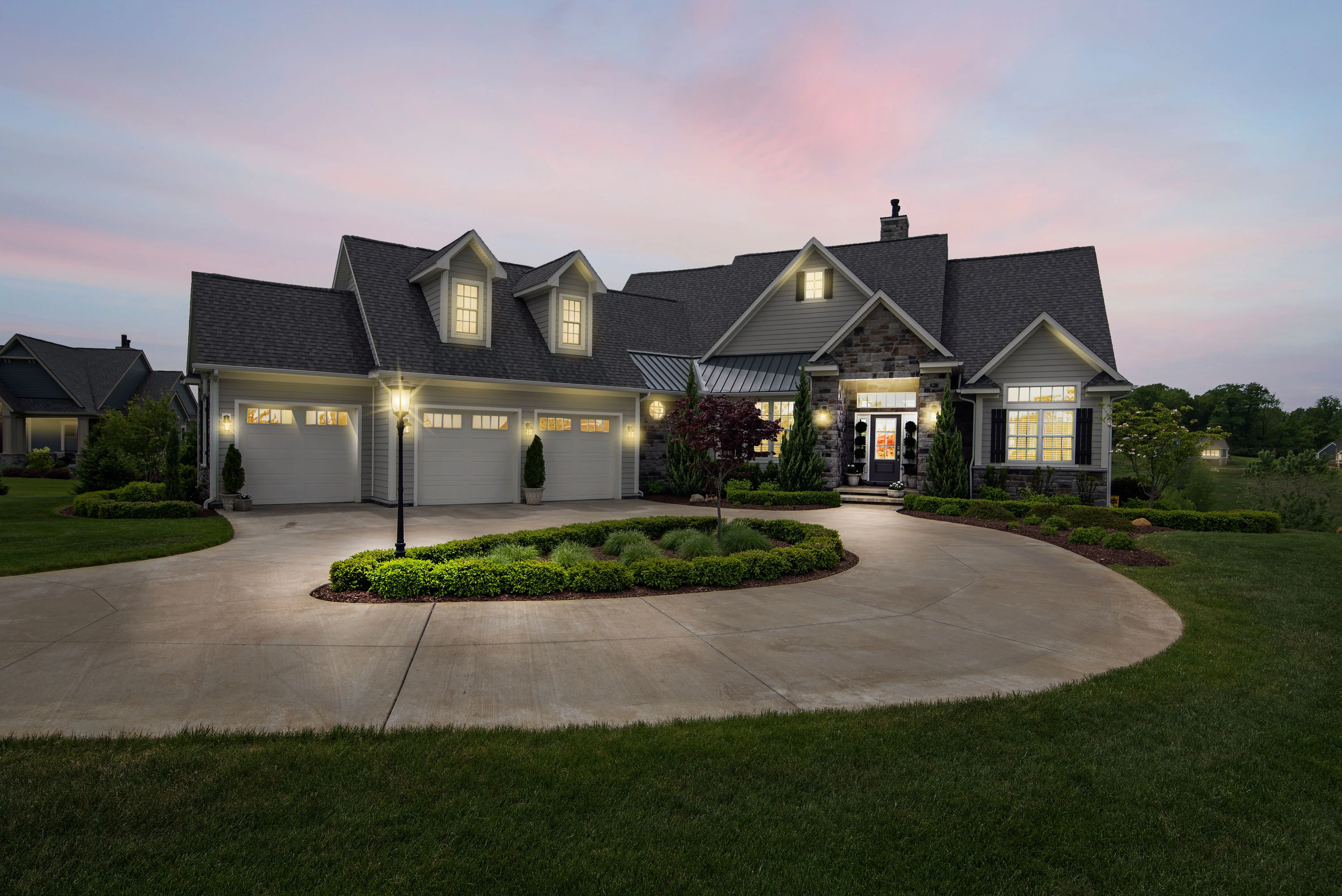 Finished circular driveway with landscaped center island at dusk