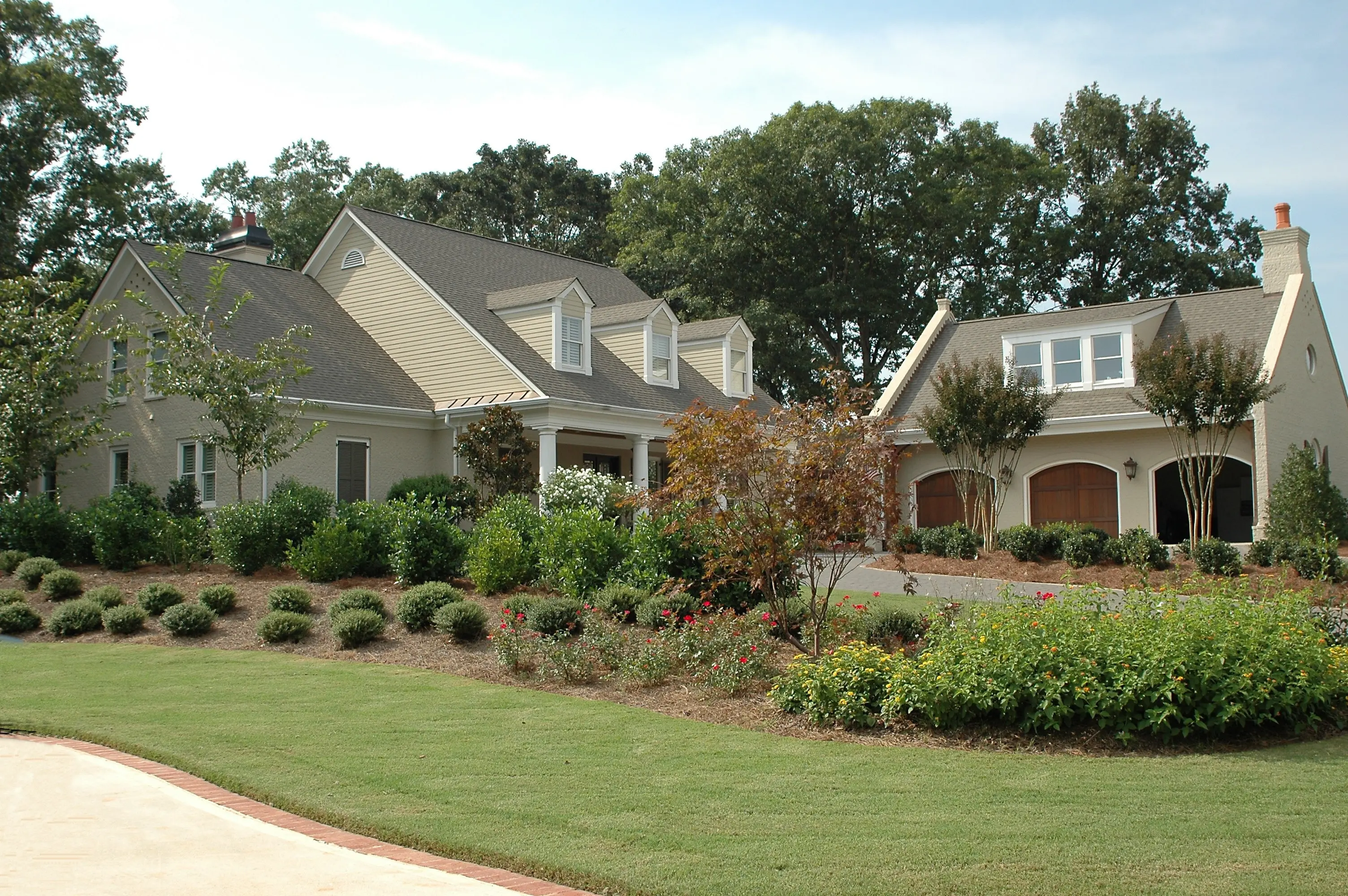 Lush garden design with layered shrubs, flowers, and mature trees